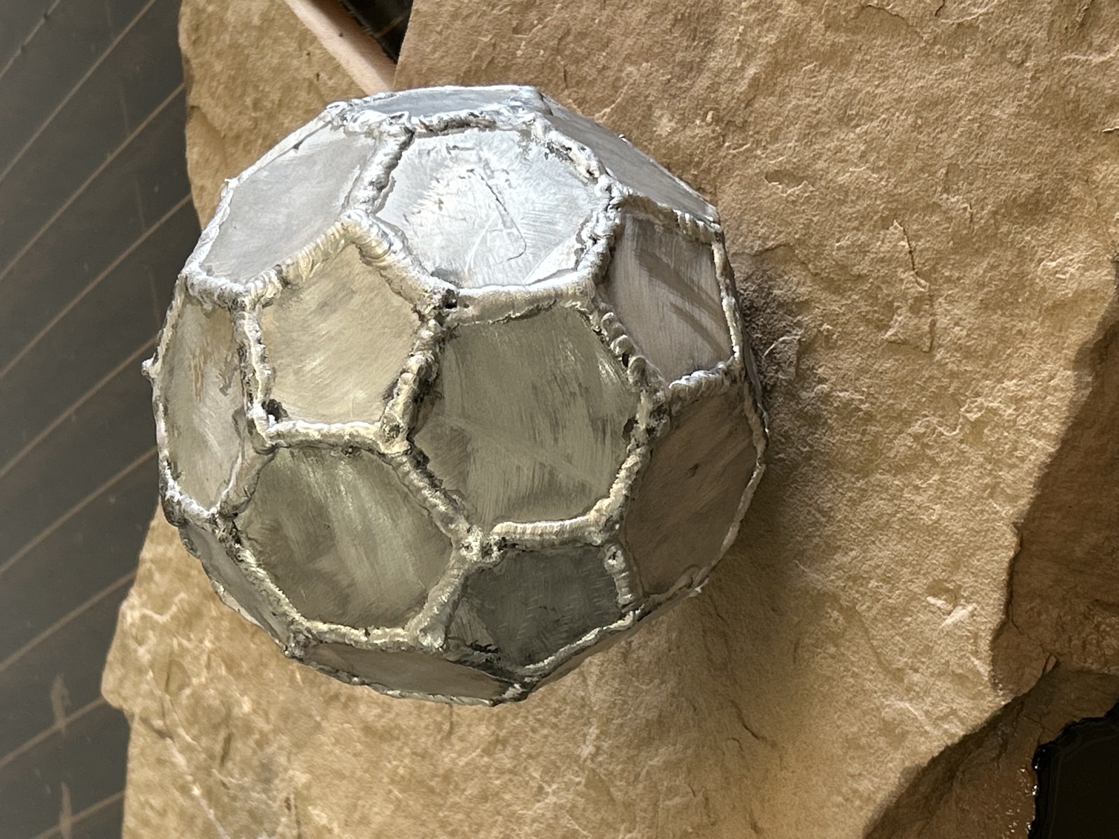 Faceted metal sphere cut from plate